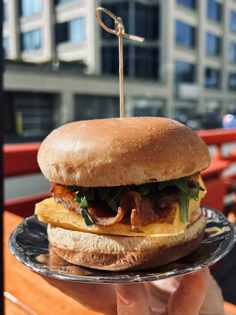 Gourmet bacon pineapple burger served outdoors.