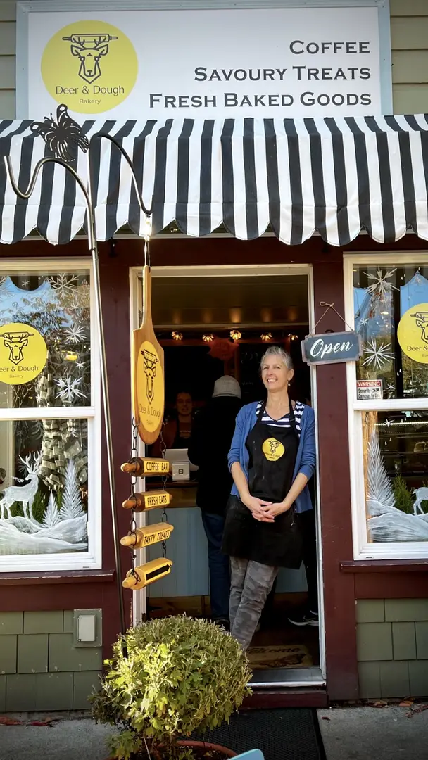 Bakery owner standing outside the shop entrance.