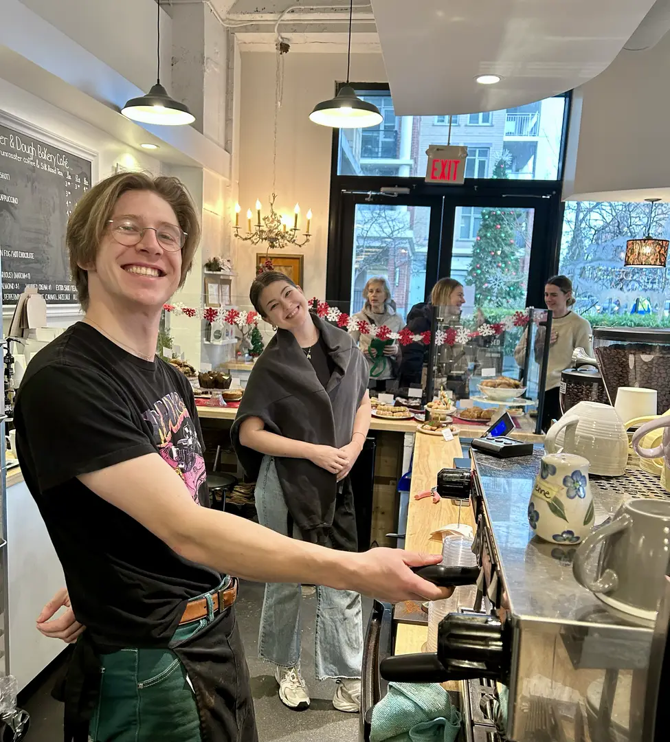 Cafe baristas smiling behind the counter.