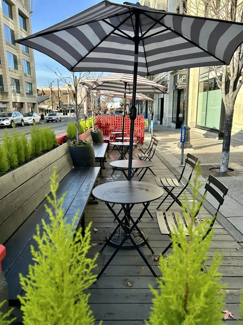 Outdoor cafe seating area with umbrellas.